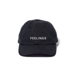 A dark-colored, unstructured 6-panel baseball cap with 'Feelings' embroidered on the front.