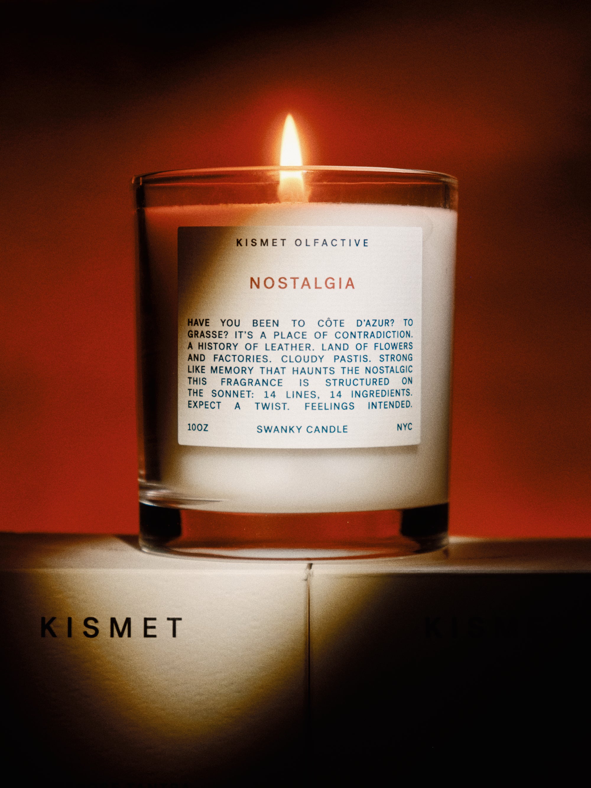 Candle labeled 'Nostalgia' by Kismet on a red background