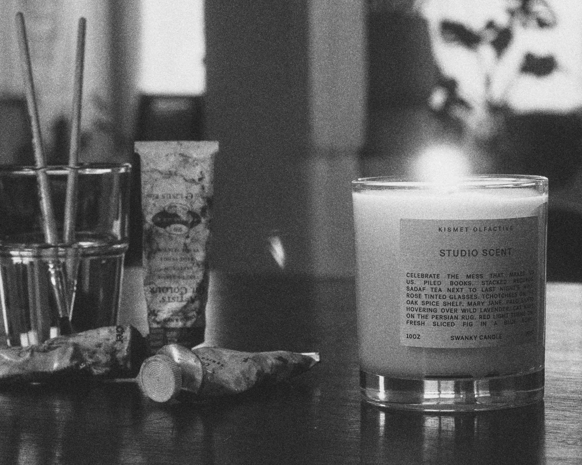 Candle with label on a table in a blurred indoor setting