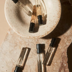 Set of small perfume bottles on a textured stone surface