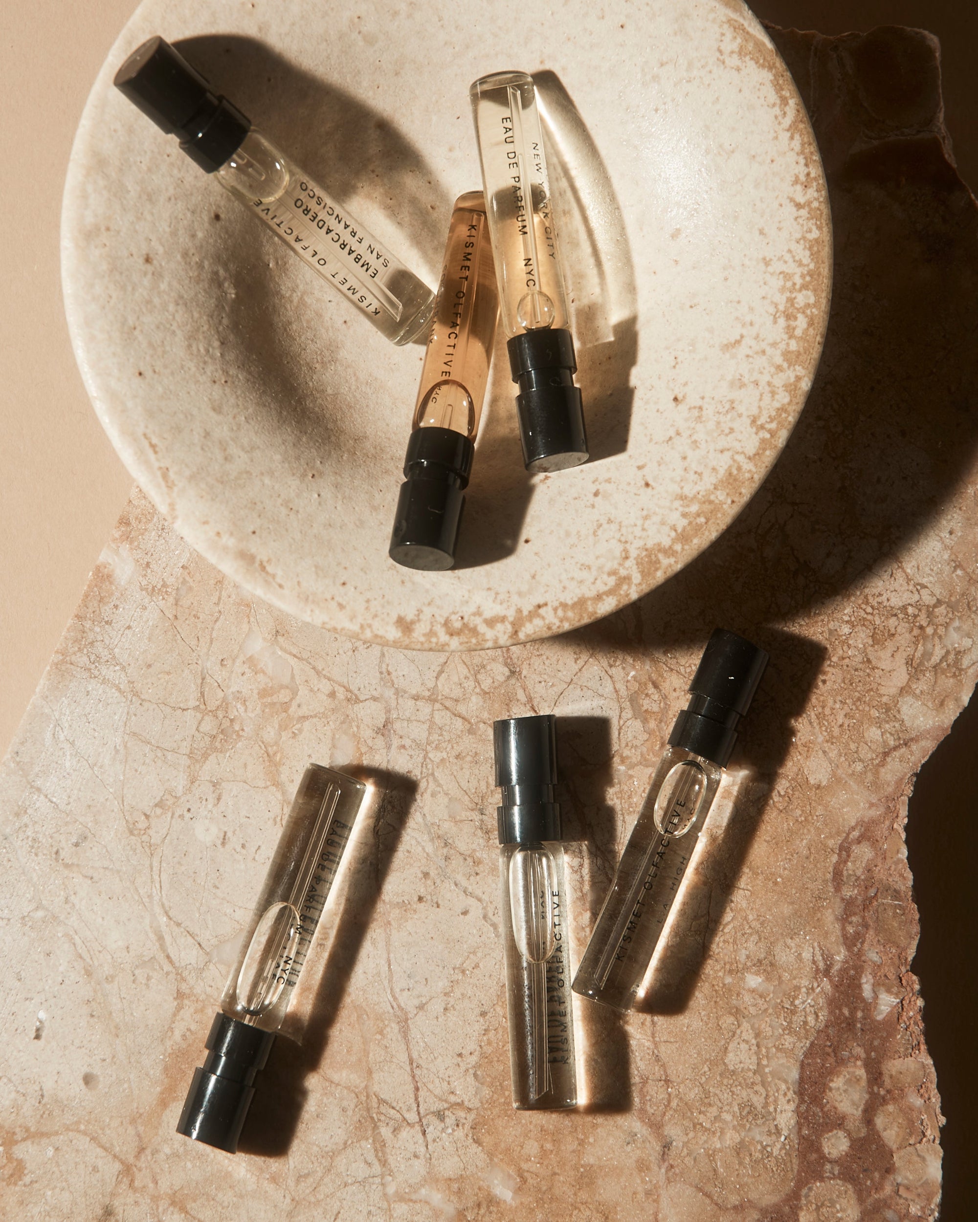 Set of small perfume bottles on a textured stone surface
