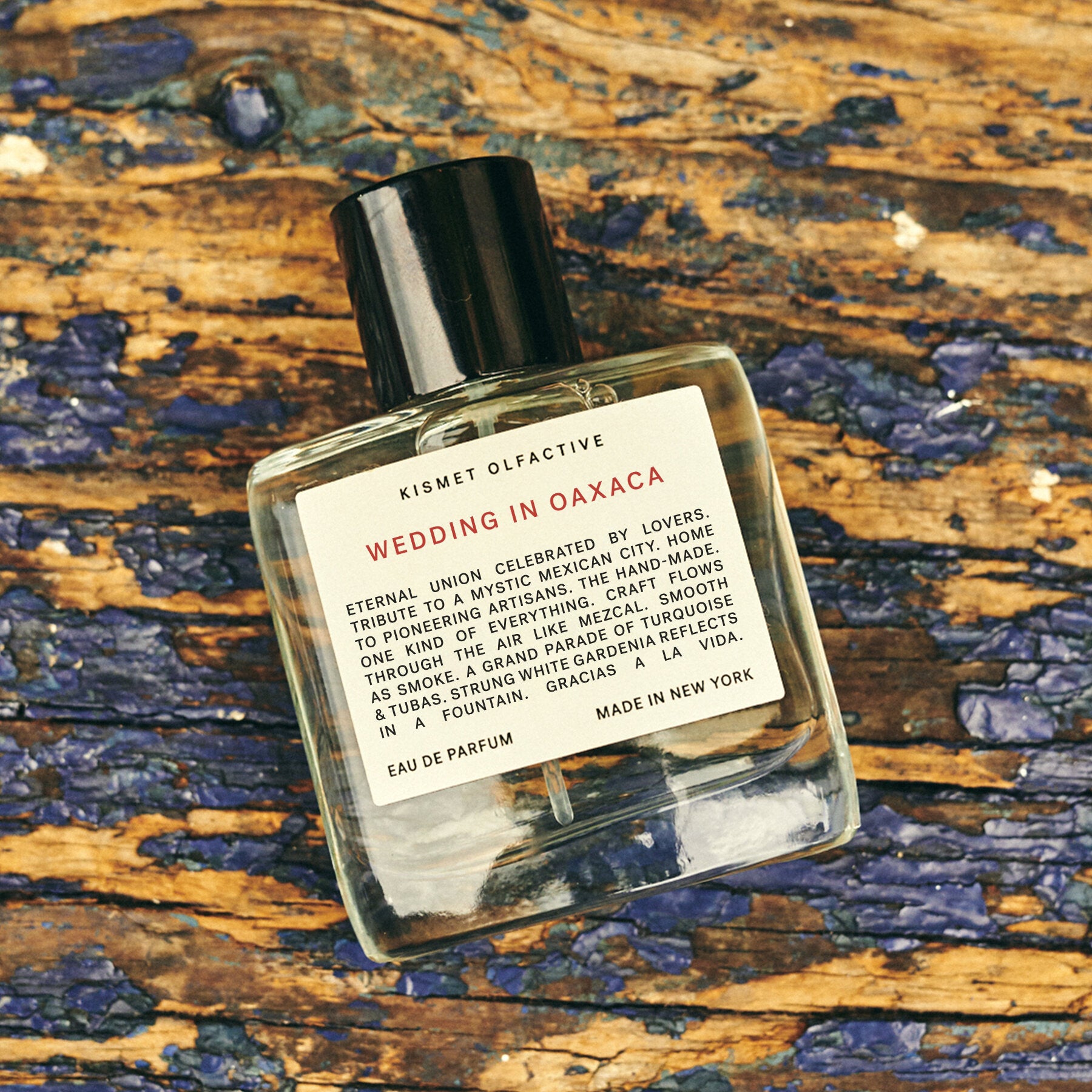 perfume bottle with label that says "wedding in oaxaca" and a natural wood background