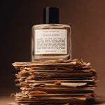 Studio Scent Perfume Bottle on top of old letters against a brown backdrop
