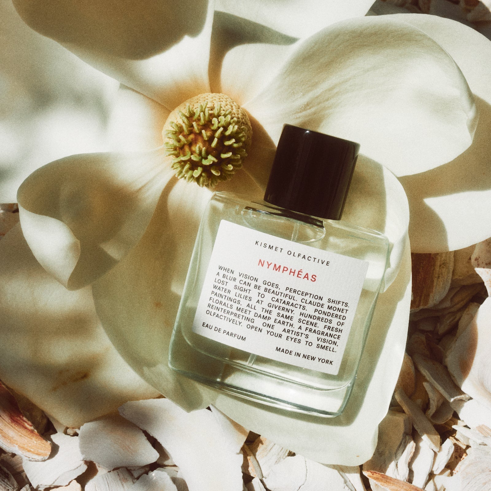 Perfume bottle labeled 'Nymphaéas' on a large white flower