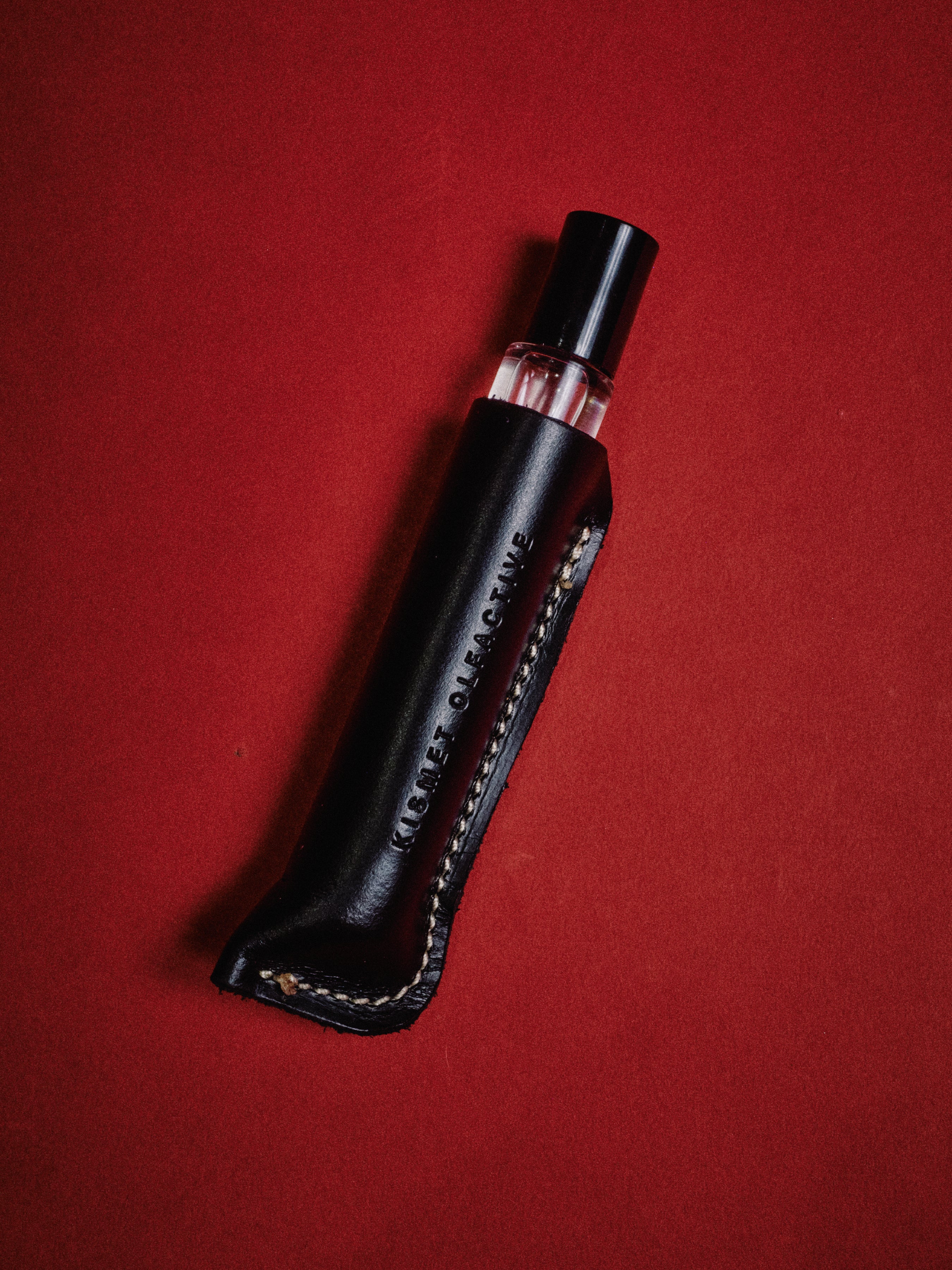 black leather travel case with a perfume inside